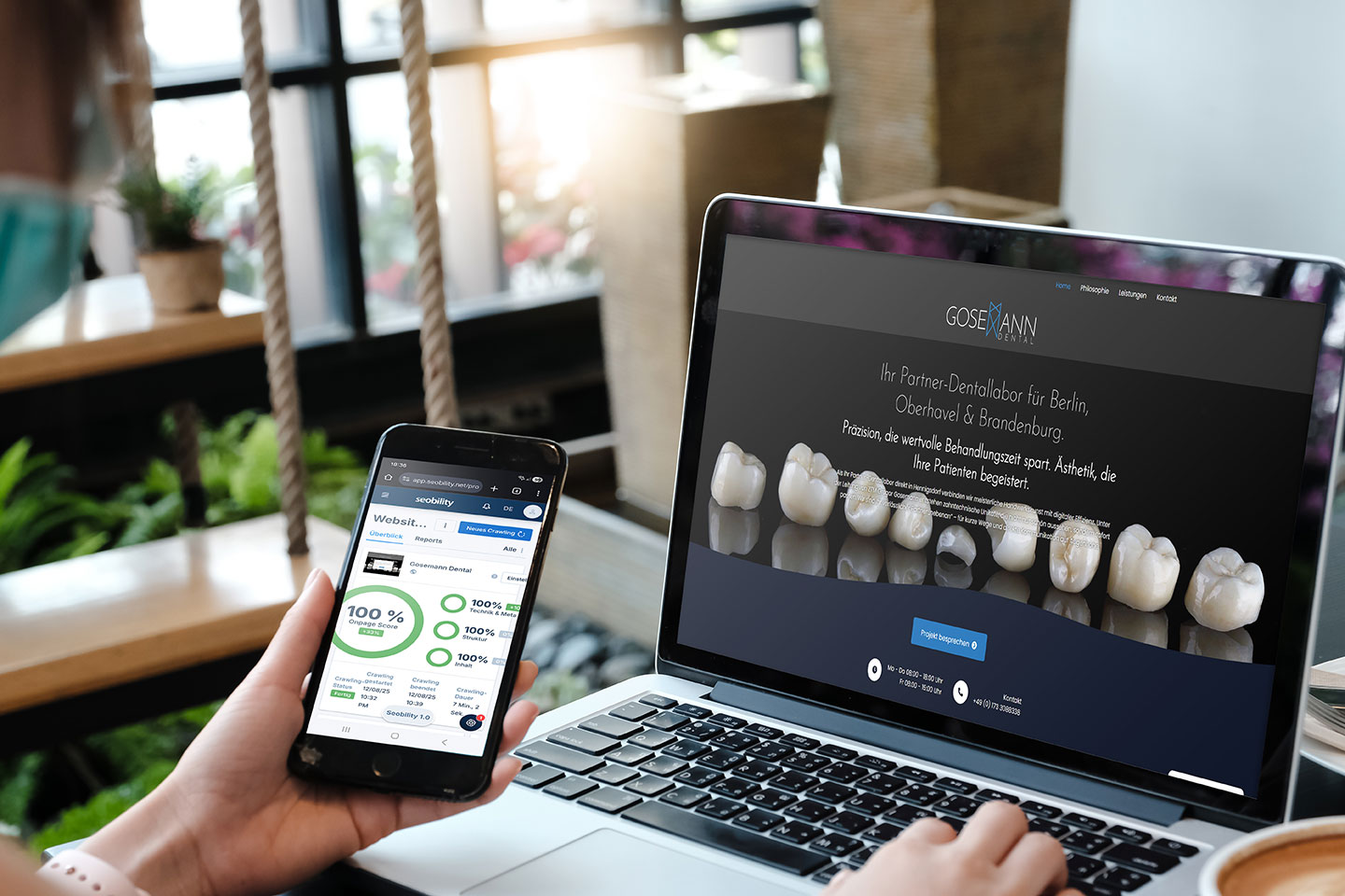Smartphone mit 100% Seobility Score vor Laptop mit neuer Gregor Gosemann Dental Website – Webdesign mit Stock-Foto-Strategie und SEO-Optimierung für Existenzgründer